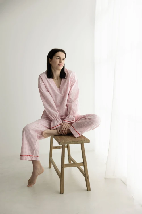 Modelka w różowej piżamie damskiej w kratkę Vichy siedząca na ławce – chwila czułości i luksusowa bawełna od Hi Dream.